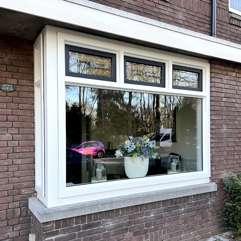 Buitenaanzicht teruggeplaatst glas-in-lood in combinatie met kunststofkozijnen in Enschede